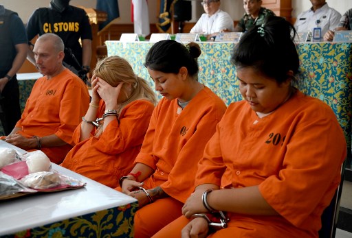(L-R) Olivier Jover of France, Tatiana Firsova of Russia, Kasarin Khamkhao and Sanicha maneetes of Thailand attend a press conference at the Customs offices near Ngurah Rai Airport in Denpasar on Indonesia’s resort island of Bali on October 21, 2019. – Two Thai women and a Frenchman could face the death penalty after they were caught smuggling drugs into Bali, the Indonesian holiday island’s customs agency said on October 21. Russian beautician Tatiana Firsova, who allegedly tried to smuggle in 6.6 grams of cocaine, was arrested after arriving in Bali on a flight from Doha last week. (Photo by SONNY TUMBELAKA / AFP)
