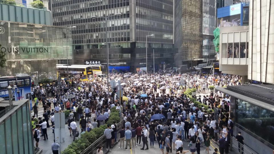 Hundreds block traffic at an intersection in Central to protest government plans to introduce an anti-mask law. Photo by Vicky Wong.