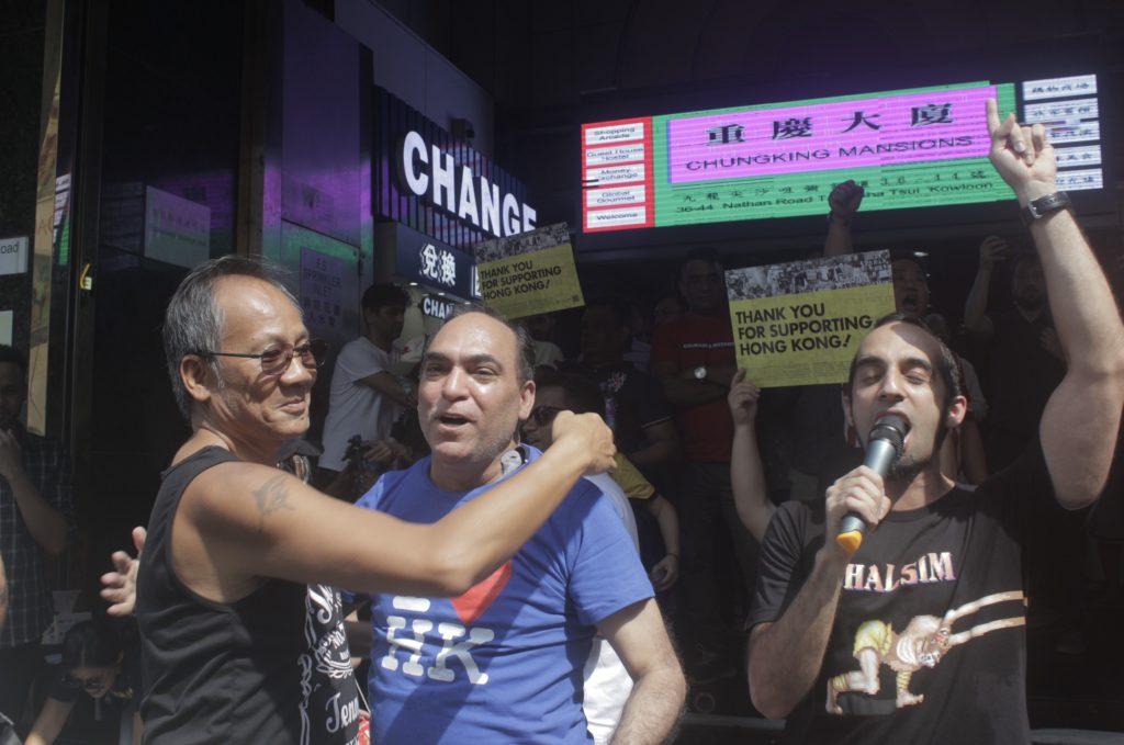 A local man hugs a South Asian man outside Chungking Mansions on Sunday, October 20. Photo by Vicky Wong.