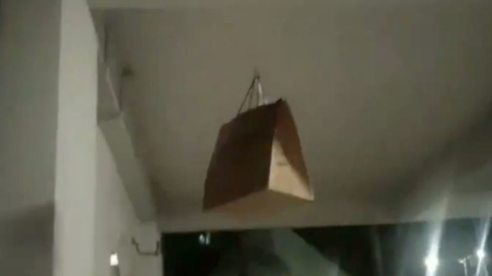 The GrabFood order being pulled several stories up to the HDB flat. Image: @_5foot4/Twitter