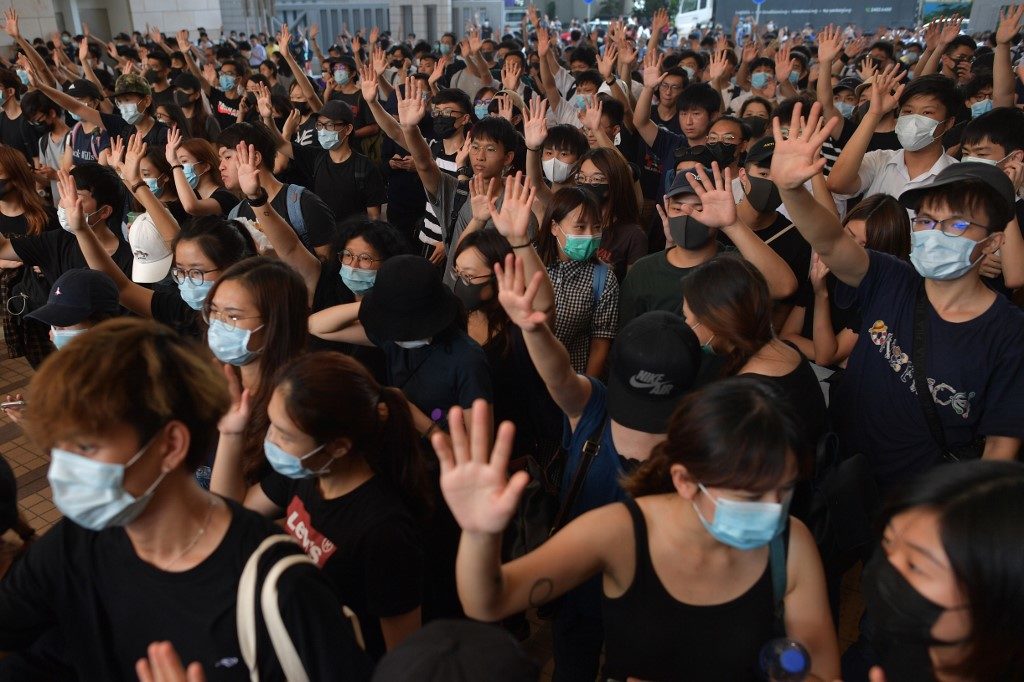 Protesters and supporters gather today outside the entrance to the West Kowloon Court in Hong Kong, where some 96 protesters arrested and charged with rioting during clashes with police on September 29 were to make an appearance in court. Photo via AFP.