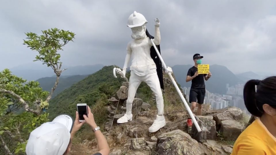 Hikers grabbing a photo with Lady Liberty Hong Kong. Screengrab via YouTube.