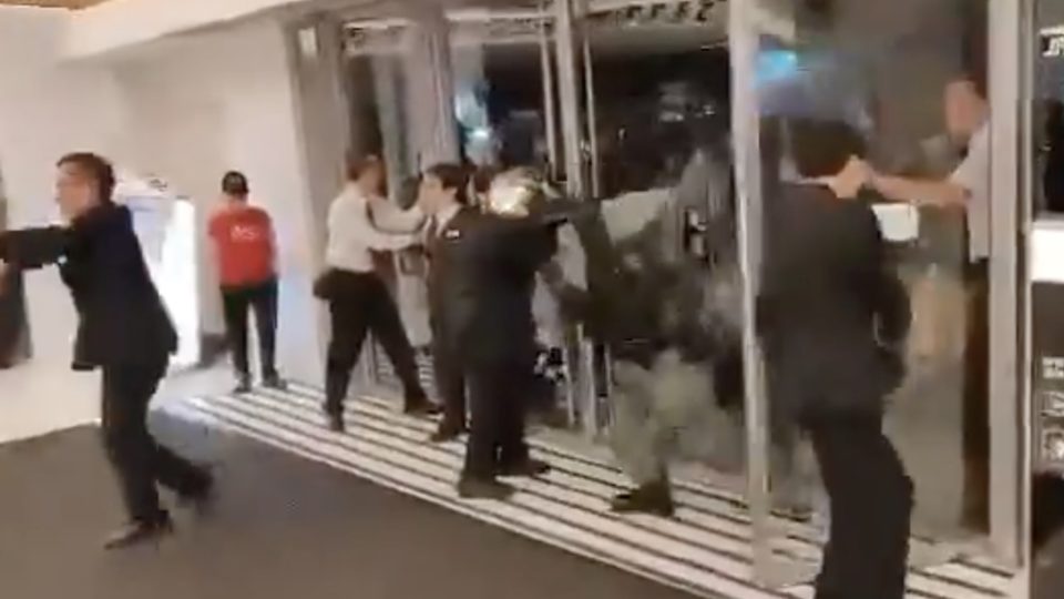 Viral video shows the moment riot police charge into a mall in Ma On Shan to arrest someone. Mall security guards can be seen trying to hold the doors closed to prevent them from entering. Screengrab via Facebook video.