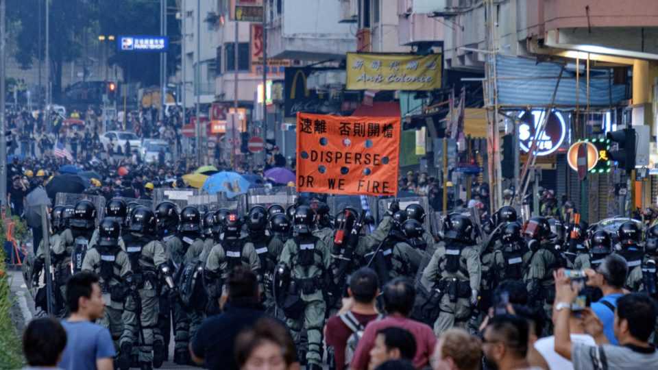 Riot police hold up a red banner in Sham Shui Po. Photo via Coconuts Media.