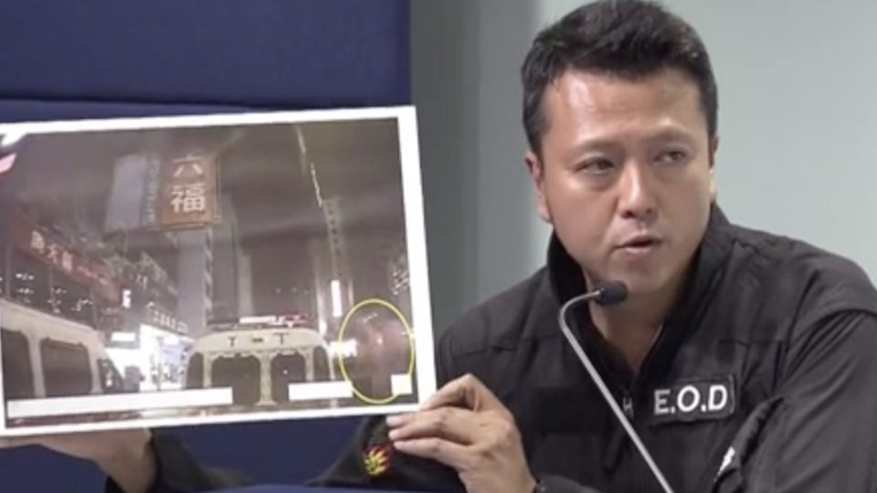 Superintendent Suryanto Chin-chiu of Explosive Ordinance Disposal Bureau holds up a photo of what they say was an explosion created through a remote-controlled device. Screengrab via Facebook/Now News.