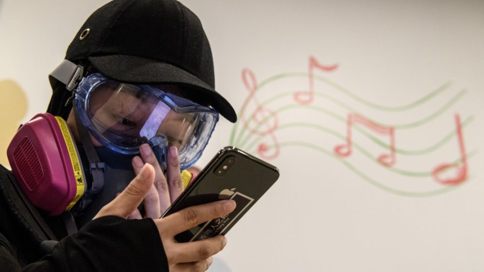 A protester uses her mobile phone inside a shopping mall during a protest in Tsuen Wan in August. Photo via AFP.