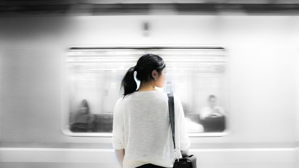 File art of a woman waiting at a train station. 