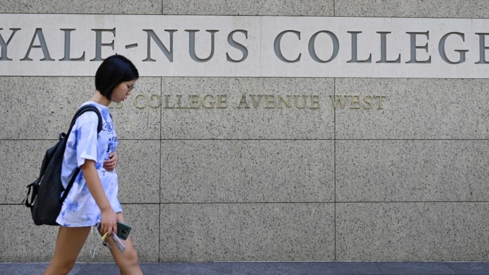 A student walks past a sign for the Yale-NUS College on Oct. 14 in Singapore. Photo: Roslan Rahman / AFP