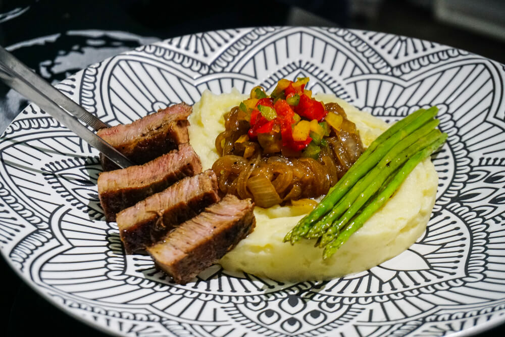 Mashed potatoes, caramelized onions, bell peppers, asparagus and roasted kurobuta pork prepared by Guiot.