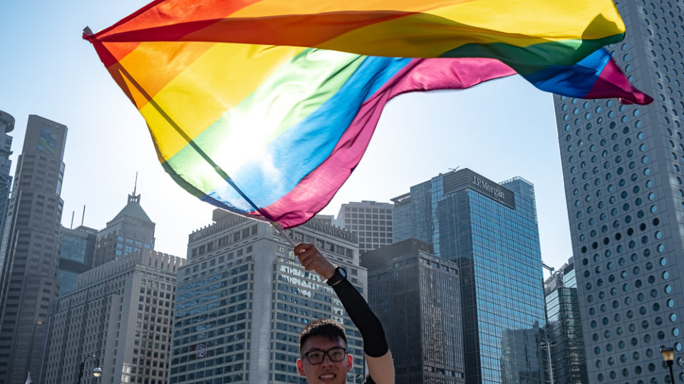 Man waves rainbow flag at the Hong Kong 2019 pride gathering. Photo by Tomas Wiik.