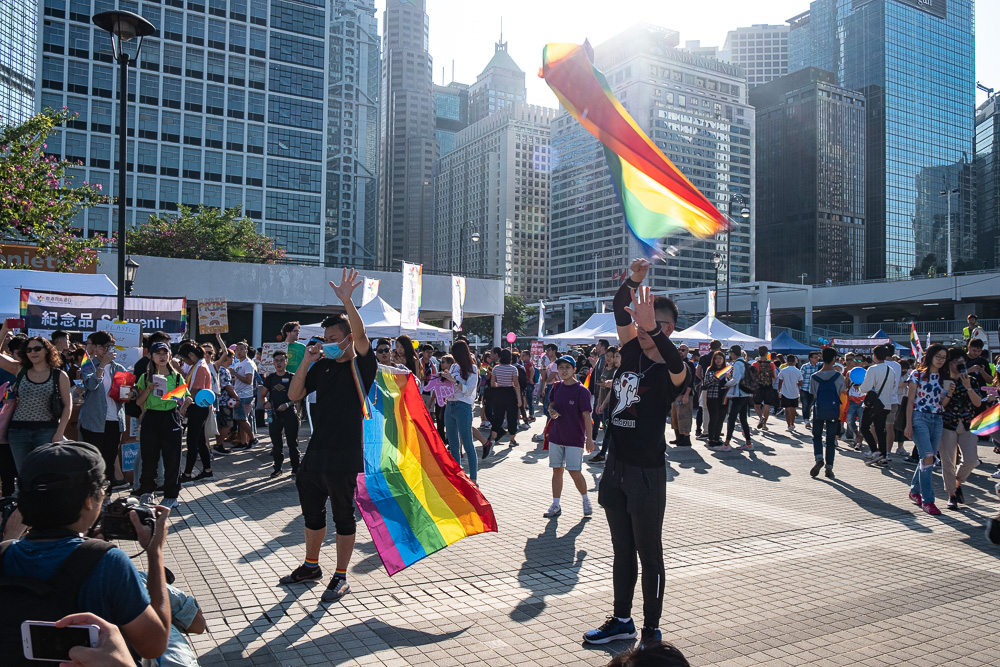 A man standing in Edinburgh Place holds up five fingers while chanting 'five demands, not one less' at Hong Kong Pride 2019. photo by Tomas Wiik.