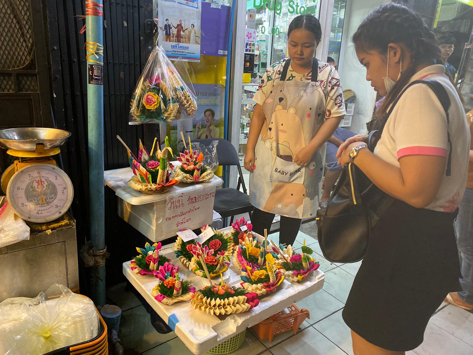 Pailin Rattanawong sells krathongs made out of corn and coconut husks Monday night in Bangkok. Photo: Coconuts