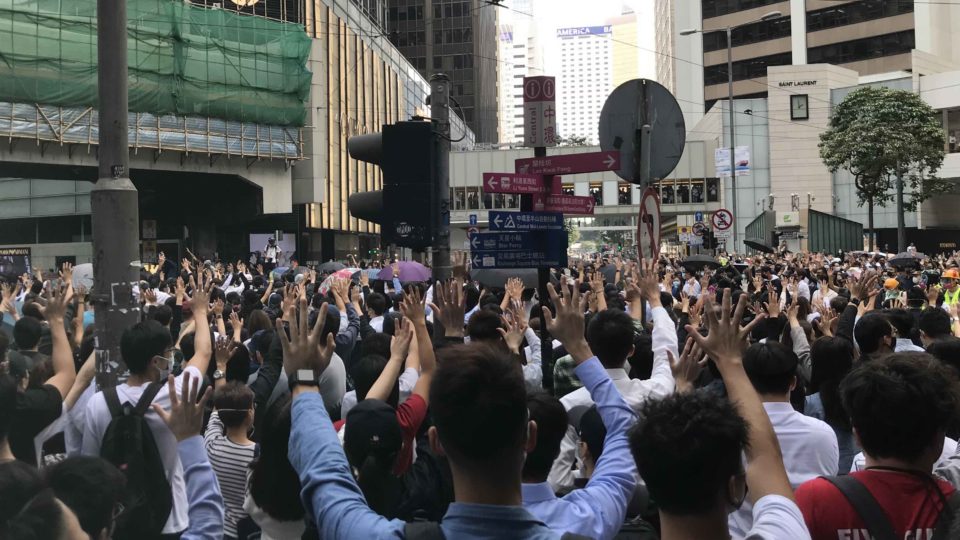 Protesters hold up five fingers during a protest in Central today, signifying “five demands, not one less.” Photo by Chad Williams.