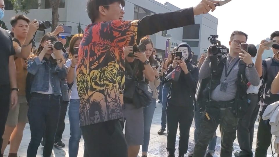 A student waves a knife and sings the Chinese national anthem at students protesting at the Chinese University of Hong Kong. Screengrab via YouTube.