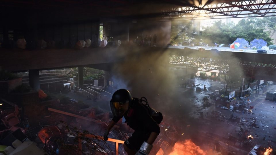 A protester walks on stairs at the barricaded main entrance of Hong Kong Polytechnic University as other protesters attempt to find safe passage out of campus on Nov. 18, 2019. Photo via AFP.