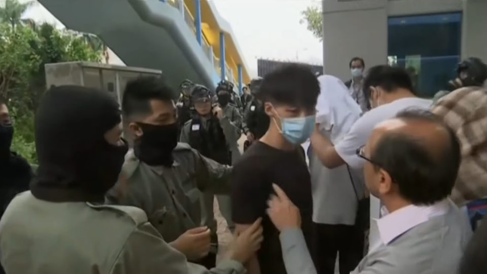A presumed protester speaks with police after crossing the police line at PolyU this week. Screengrab via YouTube.