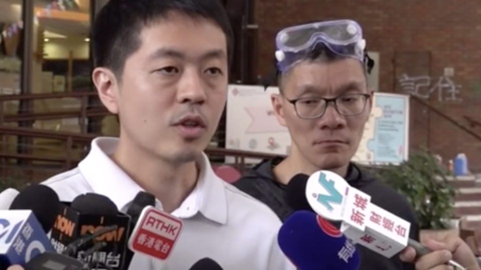 Pro-democracy lawmaker Ted Hui speaking to reporters ahead of him and dozens of protesters at Polytechnic University surrendering. Screengrab via Facebook.