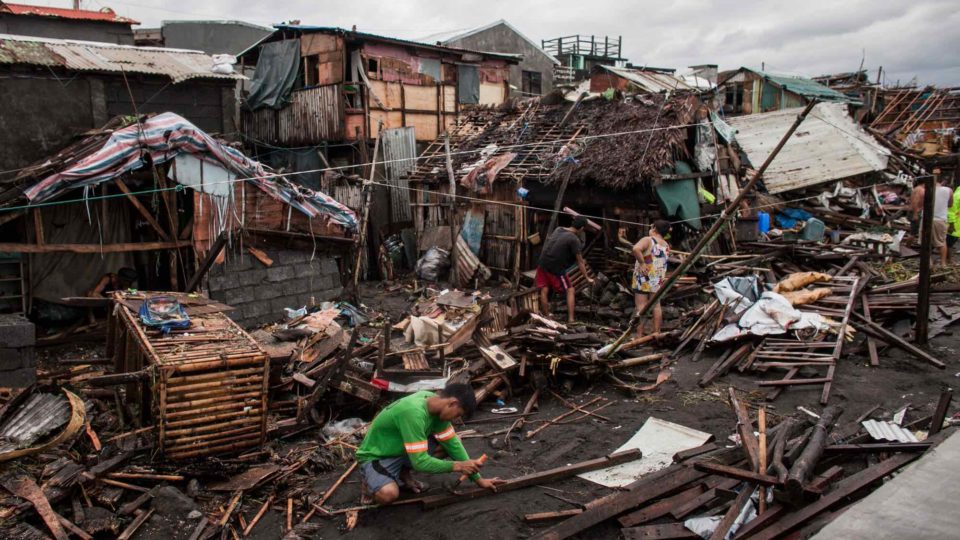 Workers repair damaged houses along the coastline of Legazpi City, Albay on Dec. 3. <I>Photo: Basilio Sepe / Greenpeace Philippines</I>