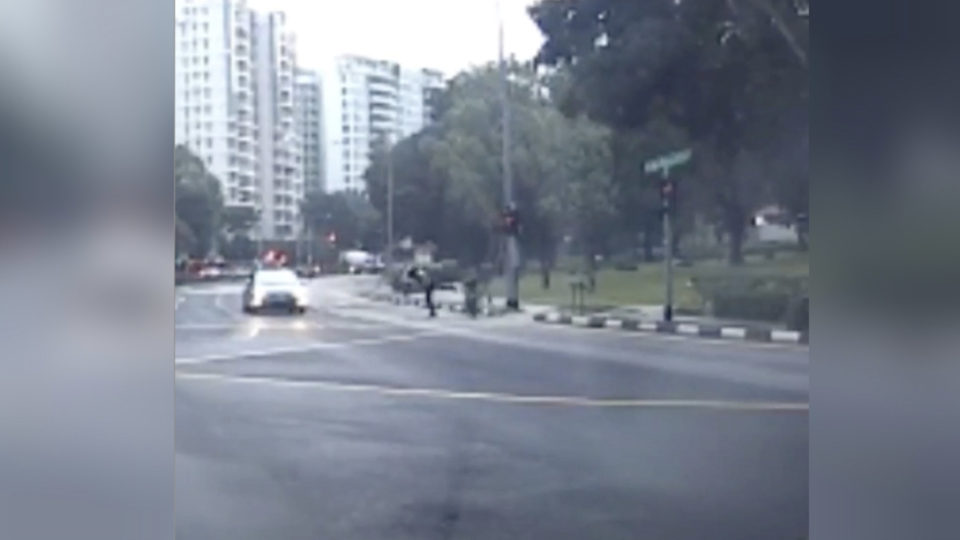 The moment a rider was kicked off his scooter at high speed onto the road Tuesday on Singapore’s Bedok Reservoir Road. Photo: Bombocey/Instagram