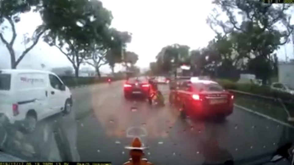 A motorcyclist falls after being sideswiped by a Trans-Cab taxi on Tuesday on Singapore’s Tampines Expressway. Photo: SG Road Vigilante/Facebook