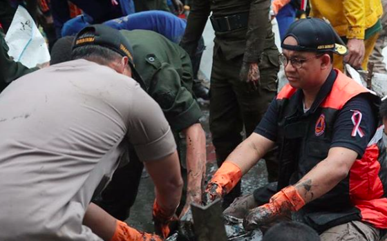 Governor Anies Baswedan (Right) helping with flood relief efforts in Jakarta. Photo: Instagram/@aniesbaswedan