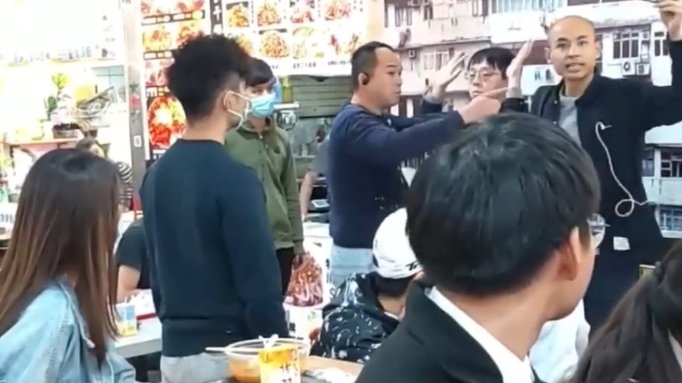 An off-duty police officer (upper right) flashes his warrant card while arresting a 23-year-old man who allegedly took his photo in a restaurant yesterday. Photo via Facebook.