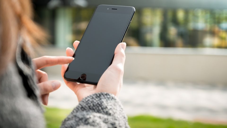 File photo of woman holding a mobile phone. Photo: Jon Vasec
