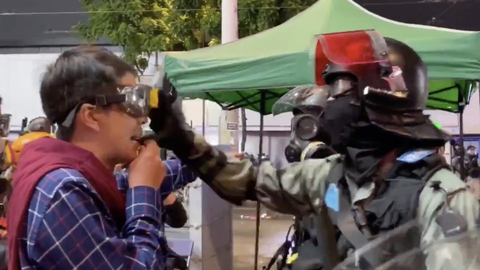 A police officer was caught on camera grabbing the goggles off the face a pro-democracy lawmaker and then pepper-spraying him at close range. Screengrab via twitter video.