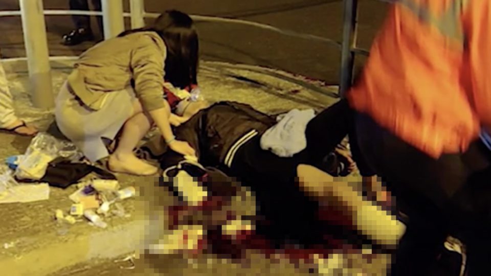District councillor and doctor Kwong Po-yin tending to a 23-year-old man who was attacked by two knife-wielding men. Screengrab via Apple Daily video.