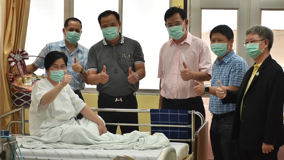 A Chinese woman who recovered from infection with the Wuhan virus poses for photos with Thai government officials including the minister of health. Photo: Department of Disease Control / FB