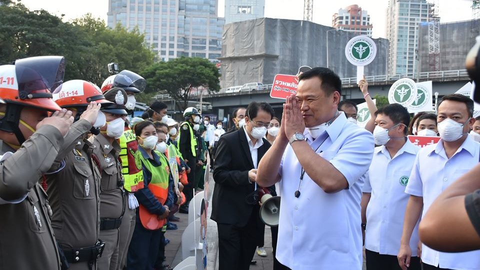 Public Health Minister Anutin Charnvirakul greets police officers at Lumphini Park. Photo: Department of Disease Control / FB

