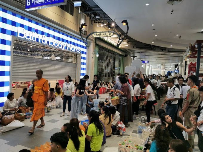 People make offerings to Buddhist monks Thursday morning at the Terminal 21 Korat shopping mall. Photo: @ChangFD / Twitter