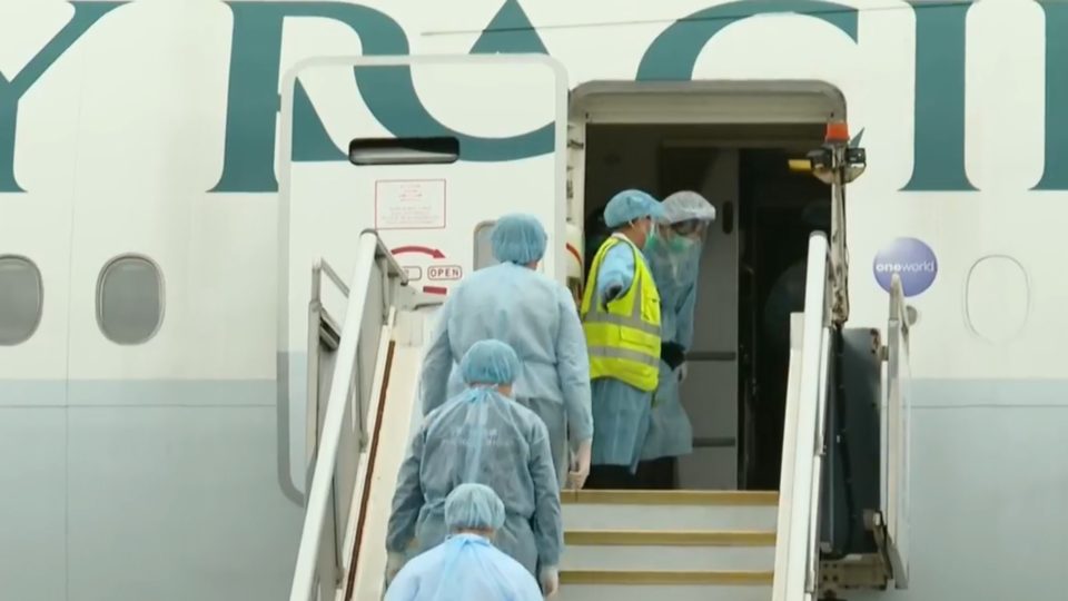 Officials board a Cathay Pacific plane carrying Hongkongers who had been quarantined on the Diamond Princess cruise ship in Japan. Screengrab via Facebook/RTHK.