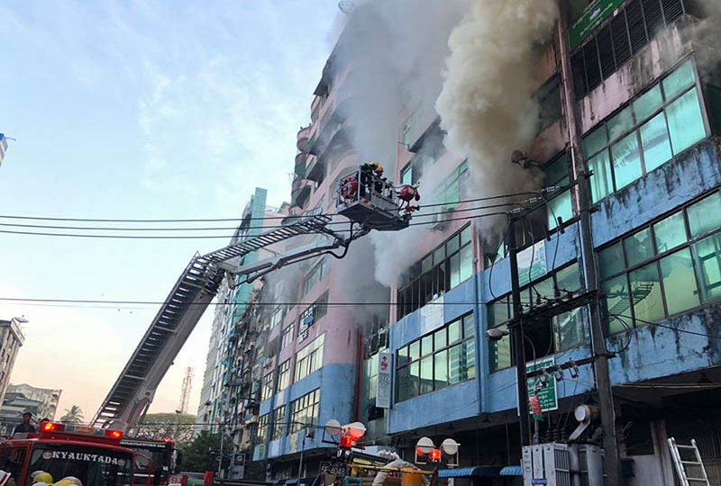 Firefighters battle flames and smoke Thursday morning at Than Zay Market fire in Yangon’s Latha township. Photo: Myanmar Fire Services Dept.