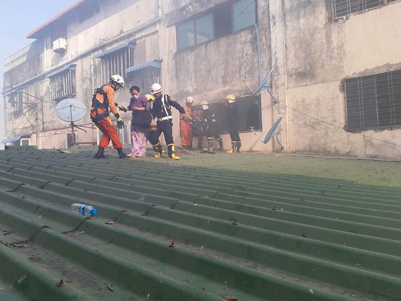 Firefighters rescue residents at Thursday morning's Than Zay Market fire in Yangon's Latha township. Photo: Myanmar Fire Services Dept.