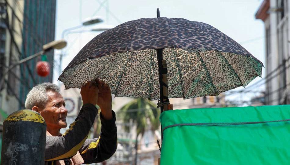 A pedicab driver fixes his umbrella under the scorching heat. <i>Photo: Jonathan Cellona, ABS-CBN News</i>