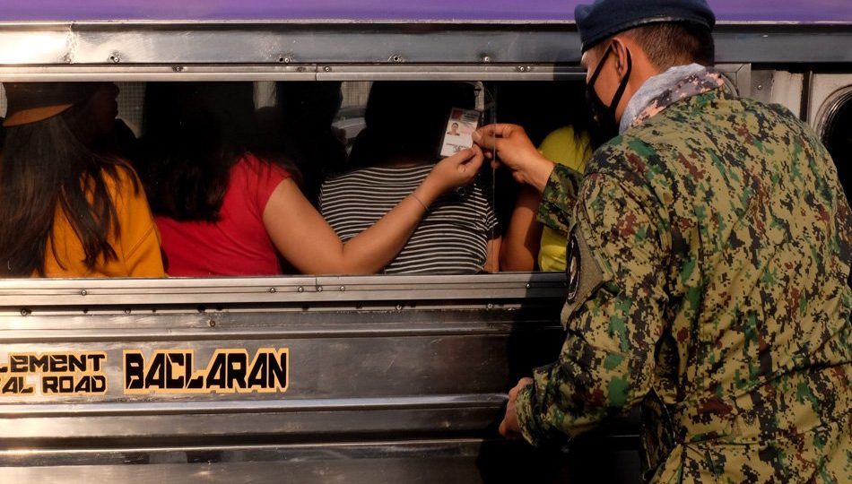 A military officer checking a commuter’s identification card during the first day of Metro Manila’s community quarantine. Photo: George Calvelo/ABS-CBN News