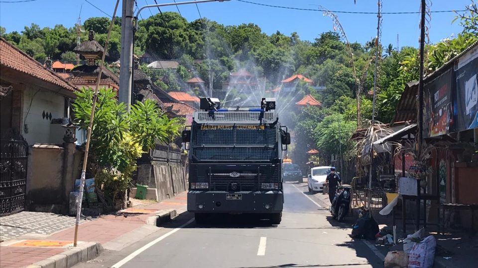 A vehicle sprays disinfectant down a street in Karangasem regency. Photo: Karangasem Regency / Twitter