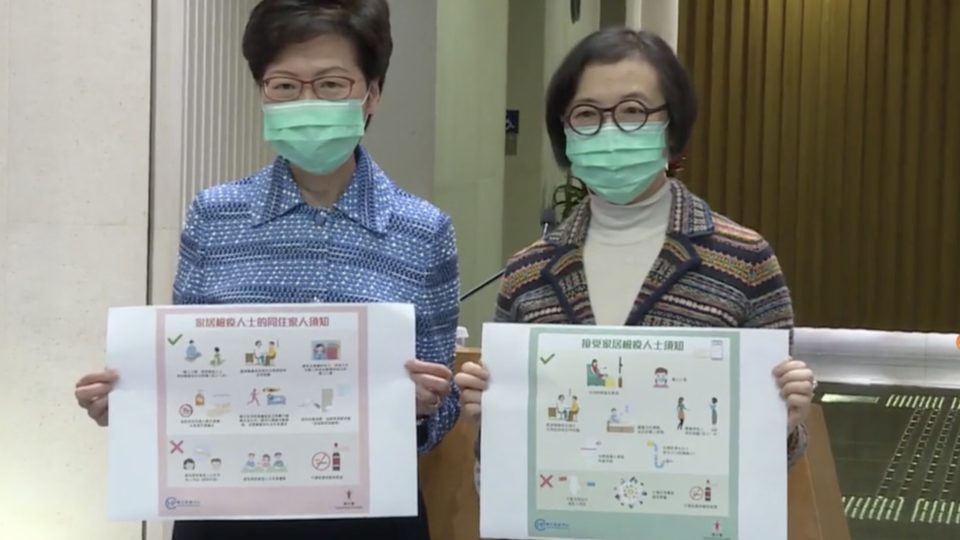 Chief Executive Carrie Lam and Health Secretary Sophia Chan hold up new posters for people under home quarantine. Screengrab via Facebook video/i-Cable.