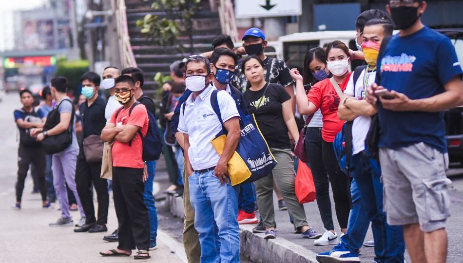 Workers wait for buses after office hours on March 16, hours after President Rodrigo Duterte declared the enhanced Luzon lockdown <i>Photo: George Calvelo / ABS-CBN News</i>