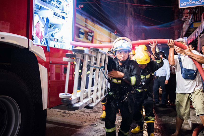 Yangon firefighters at the scene of Thursday night's blaze on 37th Street in Kyauktada Township. Photo: Ludivine Paques 