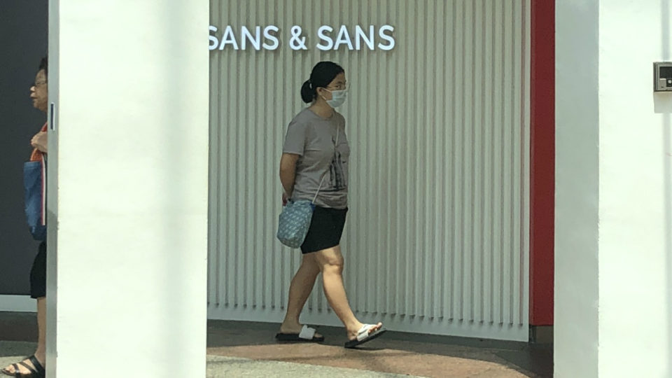 A woman wearing a mask while strolling through a mall in Singapore. Photo: Coconuts