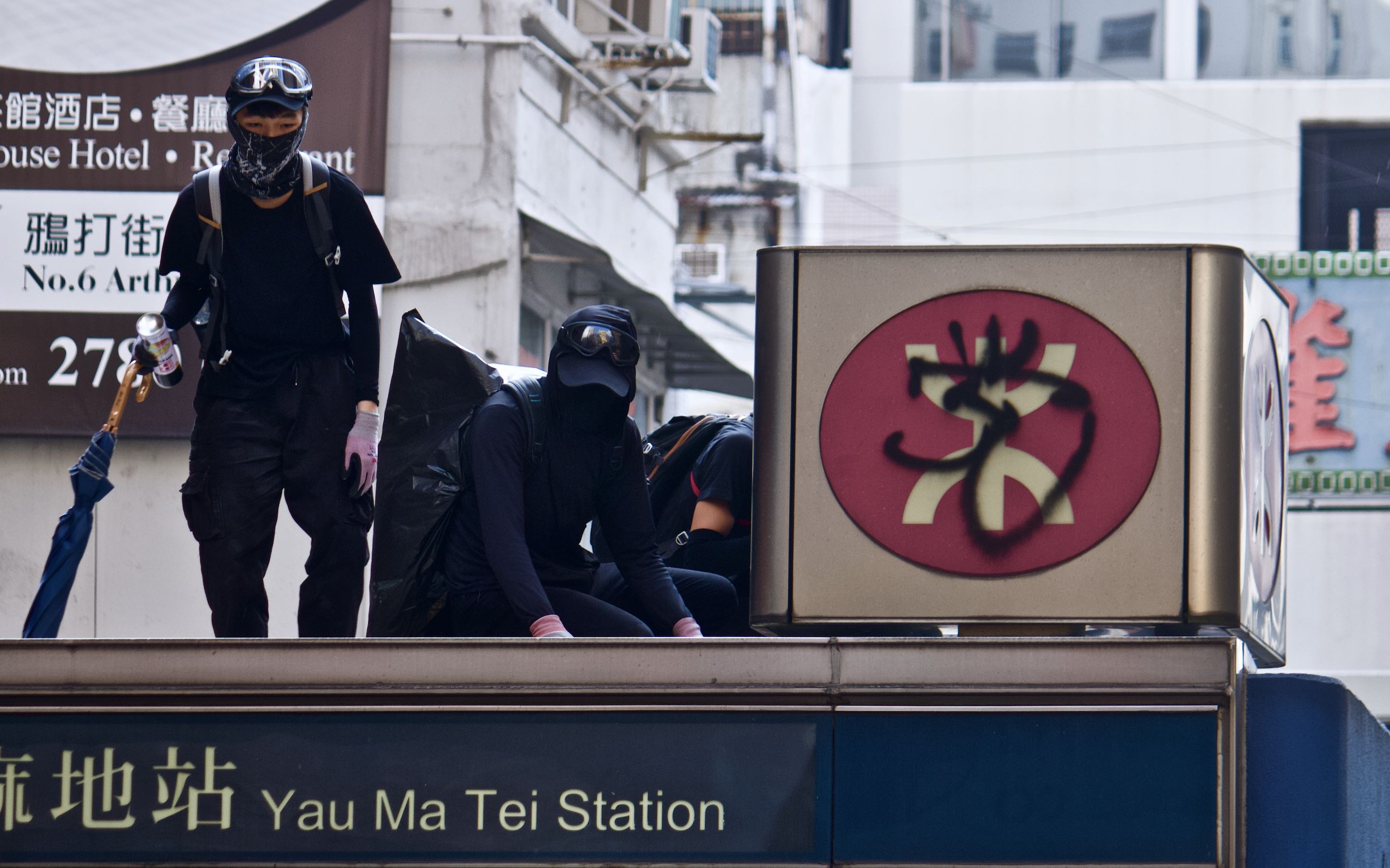 Protesters at a rally in October 2020 graffiti the MTR logo on top of an entrance at Yau Ma Tei station. Photo by Vicky Wong.