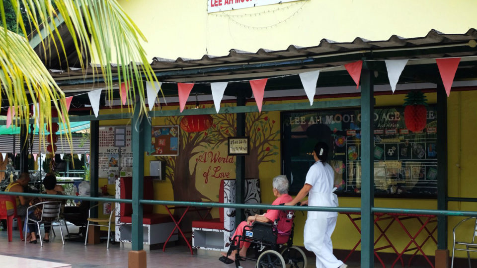 A health care worker pushes an elderly woman in a wheelchair. Photo: Lee Ah Mooi Old Age Home/Facebook