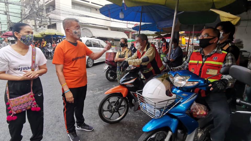 Samut Sakhon Gov. Weerasak Wichitsangsri, in orange T-shirt, talks through a face mask to a group of motorbike taxi riders. Photo: Weerasak Wichitsangsri
