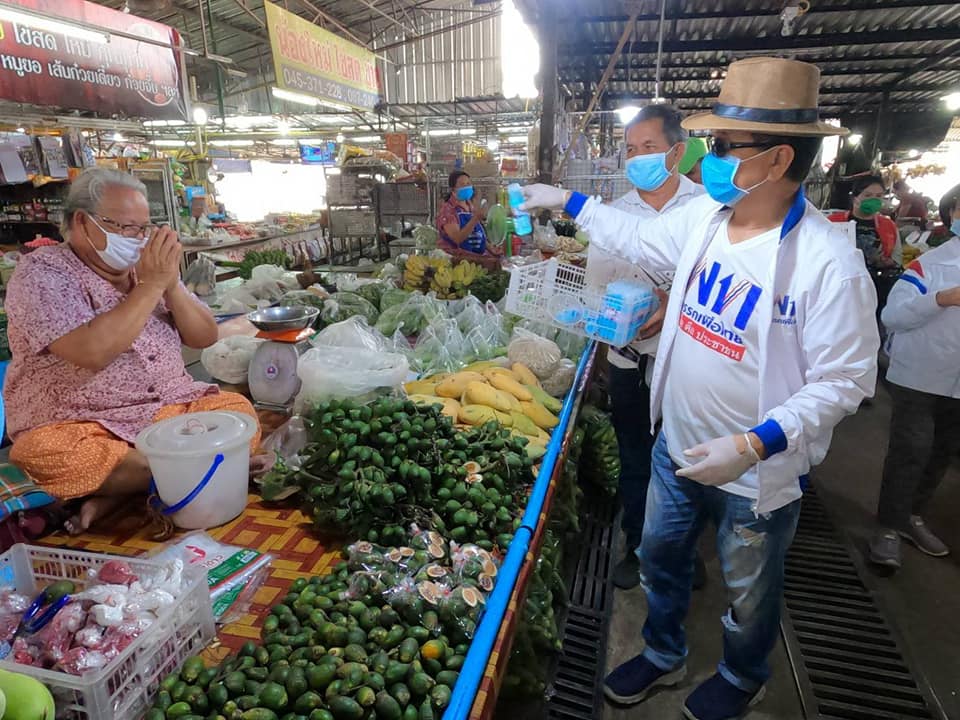 An image of Somkid Chuakong gives a hand sanitizer bottle to a local in Issan. Photo: Somkid Chuakong / Facebook 
