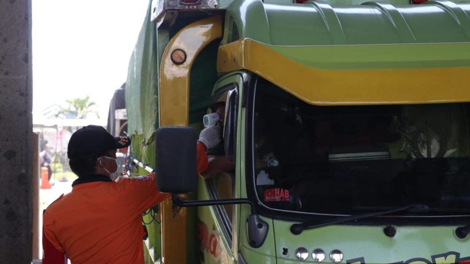 An officer conducts a temperature check on a truck driver. Photo: Bali Provincial Government