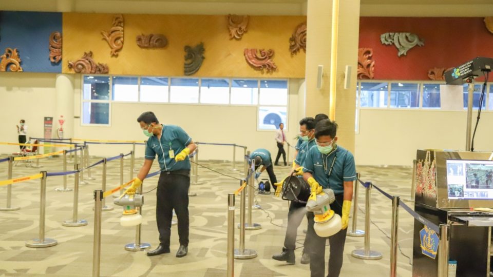 File photo of staff spraying disinfectant at the Ngurah Rai International Airport. Photo: Ngurah Rai International Airport