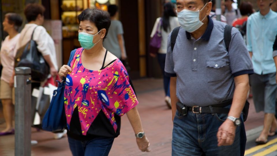 Two people wearing face masks walk through downtown Hong Kong, August 2015. Photo (for illustration): Coconuts Media