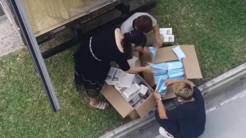 Three workers pack face masks into boxes in an image posted Monday to social media. Photo: Dee Umairah/Facebook
